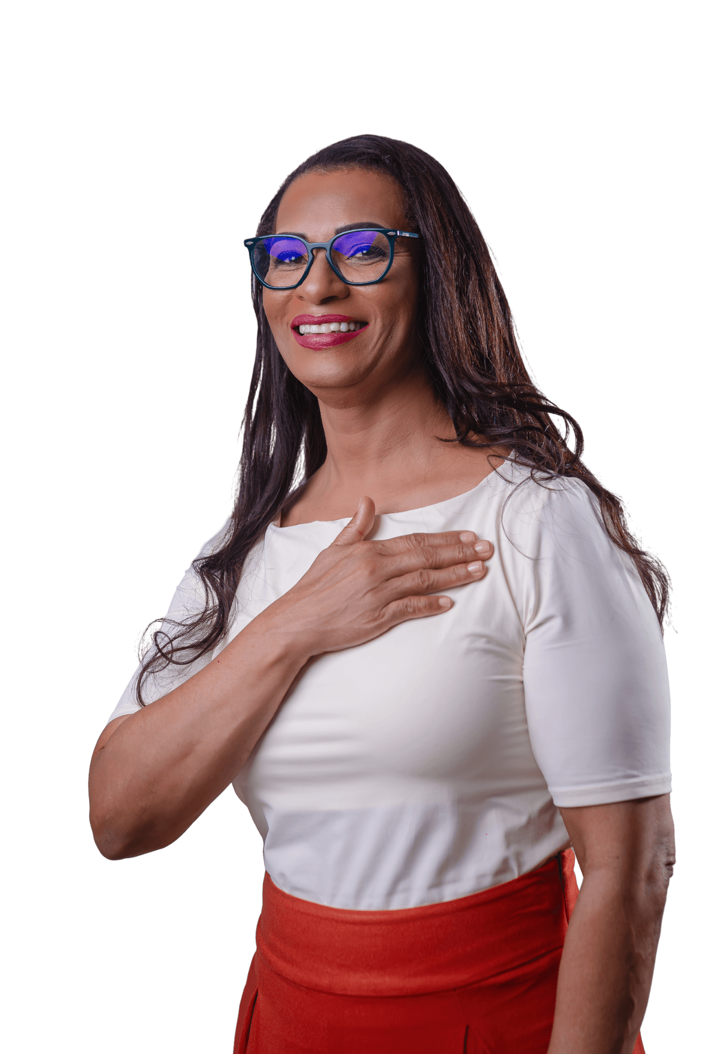 Estelita Cristo sorrindo, de óculos de armação escura, blusa branca e saia laranja, com a mão apoiada sobre o peito